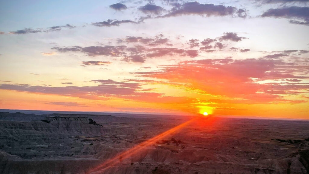 A sunset over a badlands national park