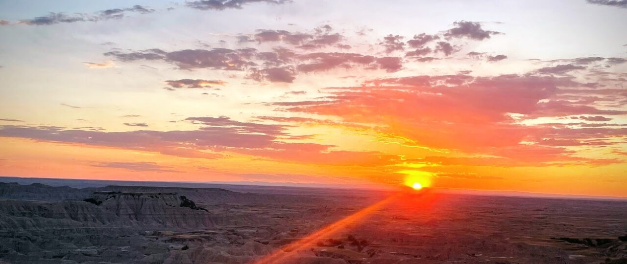 A sunset over a badlands national park