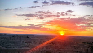 A sunset over a badlands national park