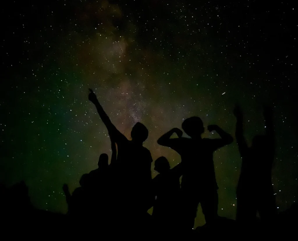 BADLANDS NATIONAL PARK AT NIGHT: WHAT TO EXPECT AFTER DARK 1 Family silhouetted against the milky way on a badlands night sky tour